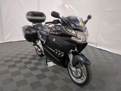 une moto noire garée sur un sol à damier