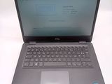 the dell laptop is open on a white surface