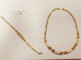 a picture of a gold necklace and bracelet on display