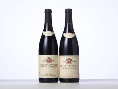 deux bouteilles de vin posées sur une table l'une à côté de l'autre
