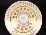 an image of a white and gold plate on a black background