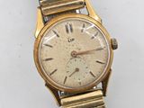 an image of a gold wrist watch with roman numerals