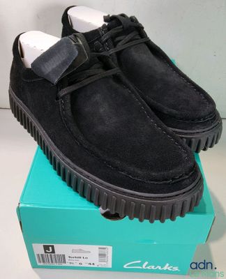 black sued shoes with a bow tie on top of a box