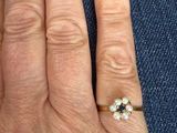 a woman ' s hand with a diamond and pearl ring on it