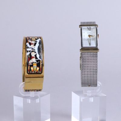 two watches sitting on display on a clear stand