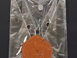 an orange medal in a clear bag on a black surface