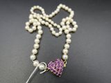 un gros plan sur un collier orné de perles et d'une fleur violette