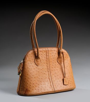 un sac à main en cuir d'autruche marron sur fond gris