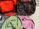 several backpacks are lined up on a bed in a room