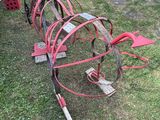 a red metal object that is sitting in the grass