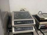 une cuisinière et une plaque de cuisson posées sur une étagère dans une cuisine
