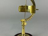 an antique brass sundial on a wooden base with a white background