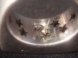 a silver ring with birds on it sitting on a counter