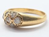 a close up of a gold ring with three diamonds