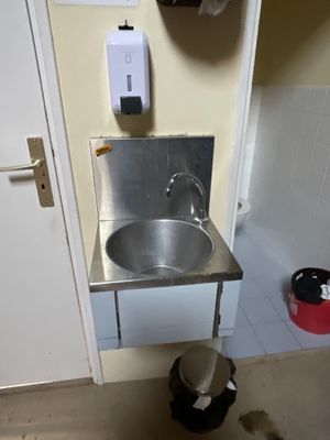 un évier en acier inoxydable dans le coin d'une salle de bains