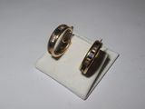 pair of gold tone hoop earrings with black enamel inlays