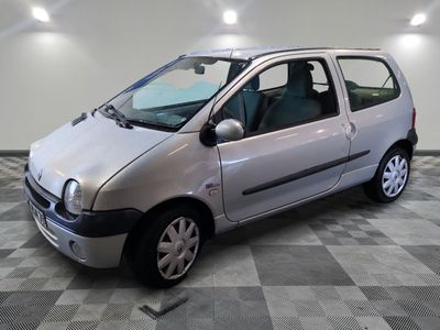une petite voiture argentée garée sur un sol en damier