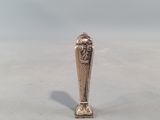 a silver vase with a face on it sitting on a table