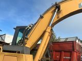 une grande pelleteuse jaune qui est à l'arrêt dans la terre