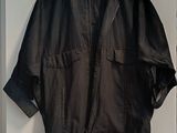 black leather jacket hanging on a white door with a black hanger
