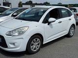 une petite voiture blanche garée dans un parking