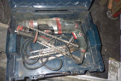 une boîte à outils contenant des outils, posée sur le sol