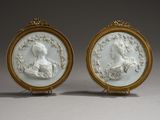 une paire de portraits, l'un blanc et l'autre plaqué or, représentant une femme et un homme