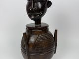 un gros plan sur une statue en bois représentant une personne, avec une tête au sommet
