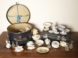 a table with a suit case and a bunch of dishes