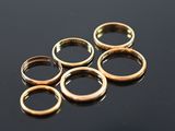 five gold rings sitting on top of a black surface