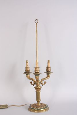 a gold colored lamp that is sitting on a table