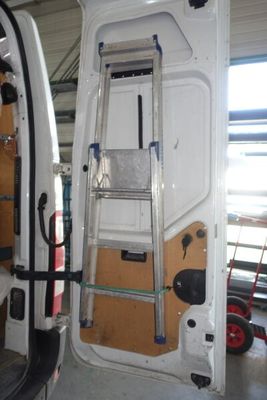 une camionnette blanche avec une échelle à l'arrière