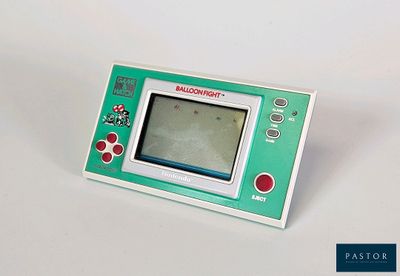 une Game Boy verte et blanche posée sur une surface blanche