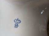 a white vase with a blue design on it