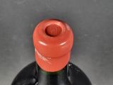 a black bottle with a red cap sitting on a table