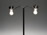 a pair of black and white lamps on a metal stand