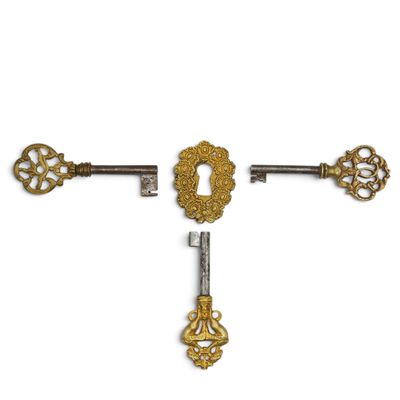 a set of three antique keys on a white background