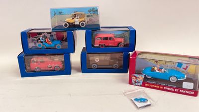 four toy cars that are sitting in boxes on a table