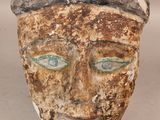 une image représentant un masque en argile aux yeux verts
