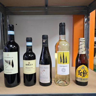several bottles of wine are lined up on a shelf in a kitchen