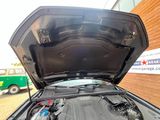une voiture dont le capot est ouvert et dont le moteur se trouve dans le coffre