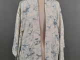 une photo d'une veste blanche et bleue posée sur un mannequin