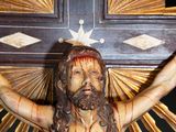 a statue of jesus holding a cross on a black background