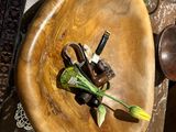 a wooden bowl with a flower in it on a table