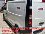 une camionnette blanche garée devant un immeuble au toit rouge