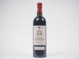a bottle of red wine sitting on top of a white table