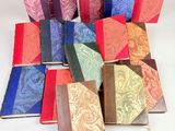 several different colored books are arranged in a circle on a white surface