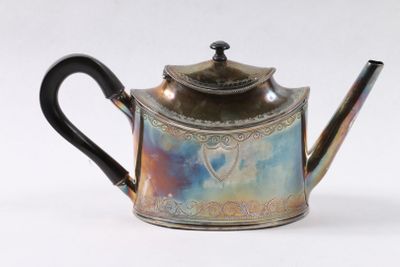 une théière en argent ornée d'un motif bleu et violet