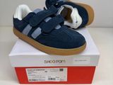 des chaussures bleues et blanches posées sur une boîte, sur une surface blanche