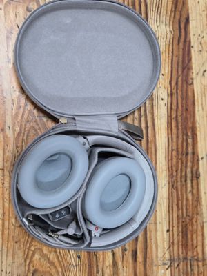 a pair of headphones in a case on a wooden floor